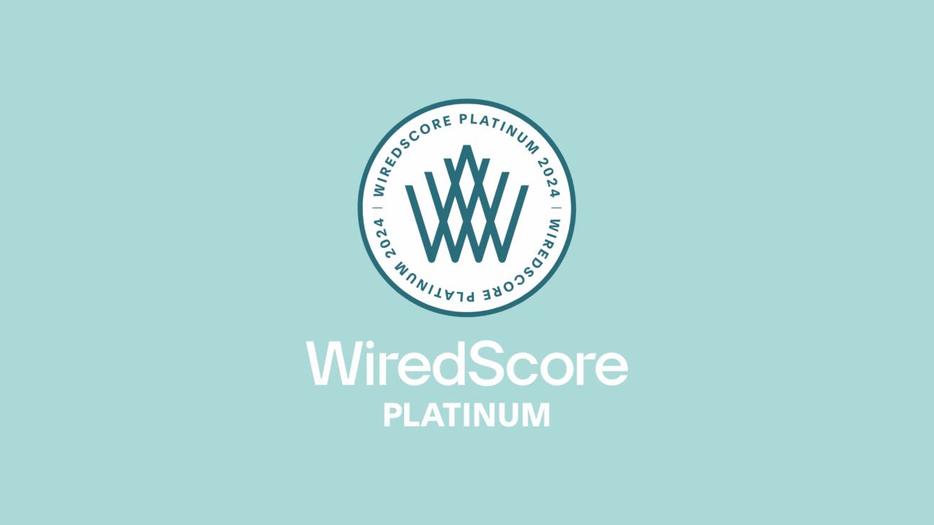WiredScore Platinum badge next to smart tech setup in modern studio